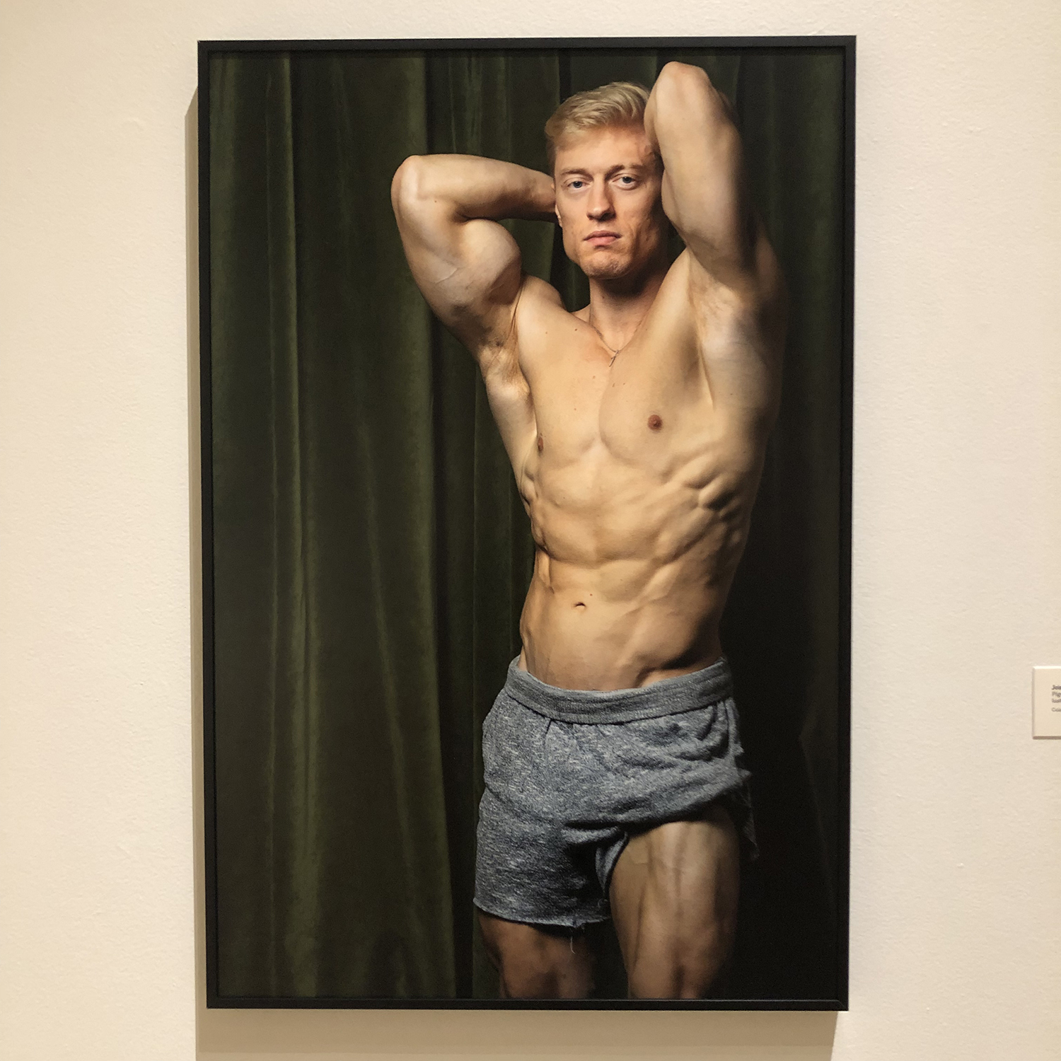 a white man with blonde hair posing with his shirt off and one short leg rolled up